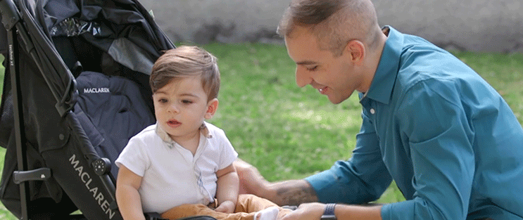 Achilles, a nerve repair patient, plays with his son, who is sitting in a stroller